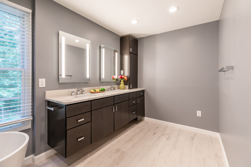 Inspiration for a mid-sized contemporary master bathroom in DC Metro with flat-panel cabinets, grey cabinets, a freestanding tub, a corner shower, a one-piece toilet, grey walls, an undermount sink, grey floor, a hinged shower door, white benchtops, an enclosed toilet, a double vanity and a floating vanity.