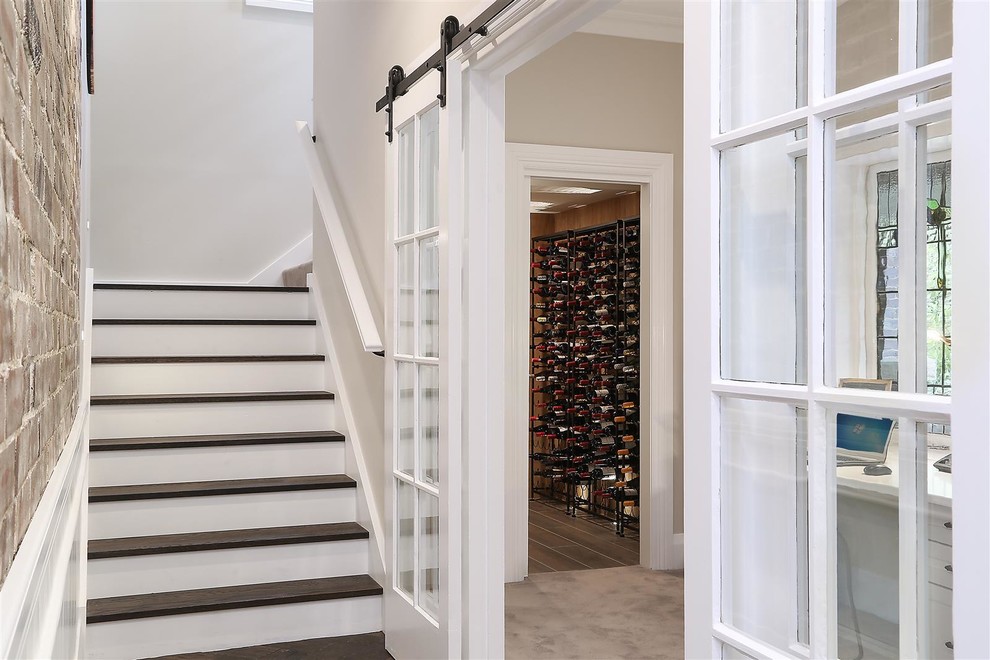 This is an example of a traditional wine cellar in Sydney with light hardwood floors, storage racks and beige floor.