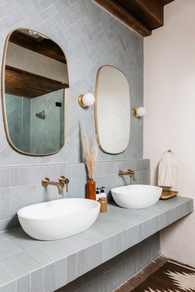 Inspiration for a mid-sized country master bathroom in Phoenix with an alcove shower, white tile, white walls, tile benchtops, beige floor, a hinged shower door, blue cabinets and blue benchtops.
