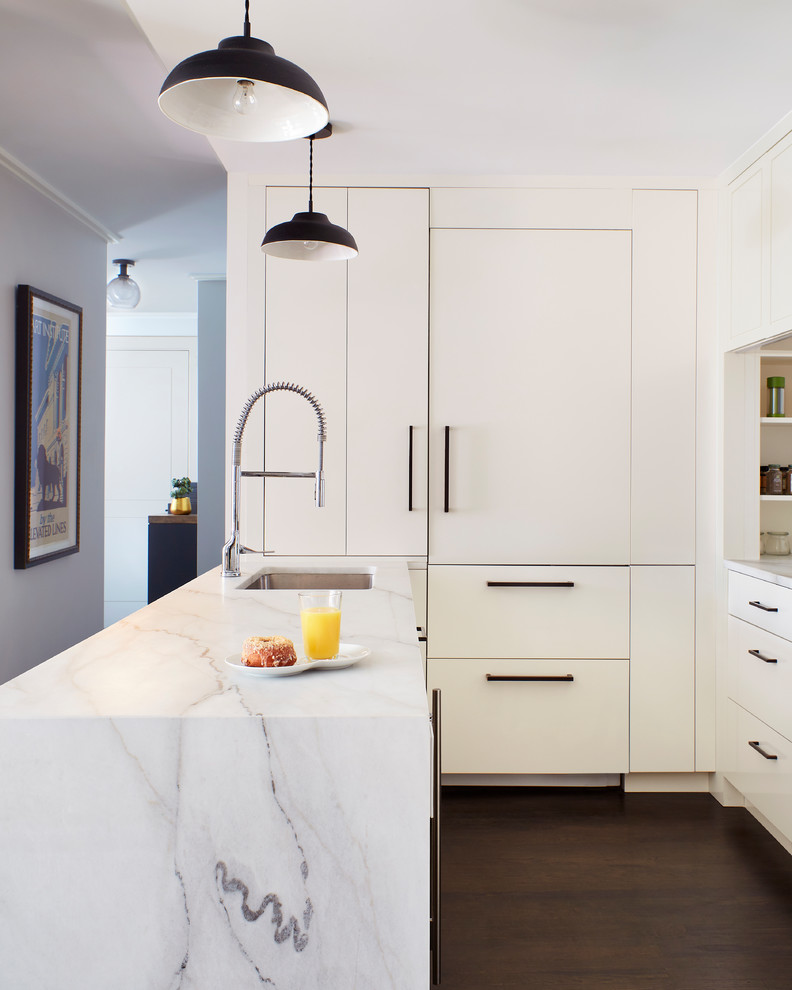 Design ideas for a contemporary l-shaped kitchen in New York with an undermount sink, flat-panel cabinets, white cabinets, dark hardwood floors, with island, brown floor and white benchtop.