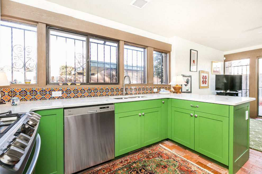 Design ideas for a mid-sized transitional u-shaped open plan kitchen in Albuquerque with a double-bowl sink, shaker cabinets, green cabinets, marble benchtops, multi-coloured splashback, porcelain splashback, stainless steel appliances, brick floors and a peninsula.