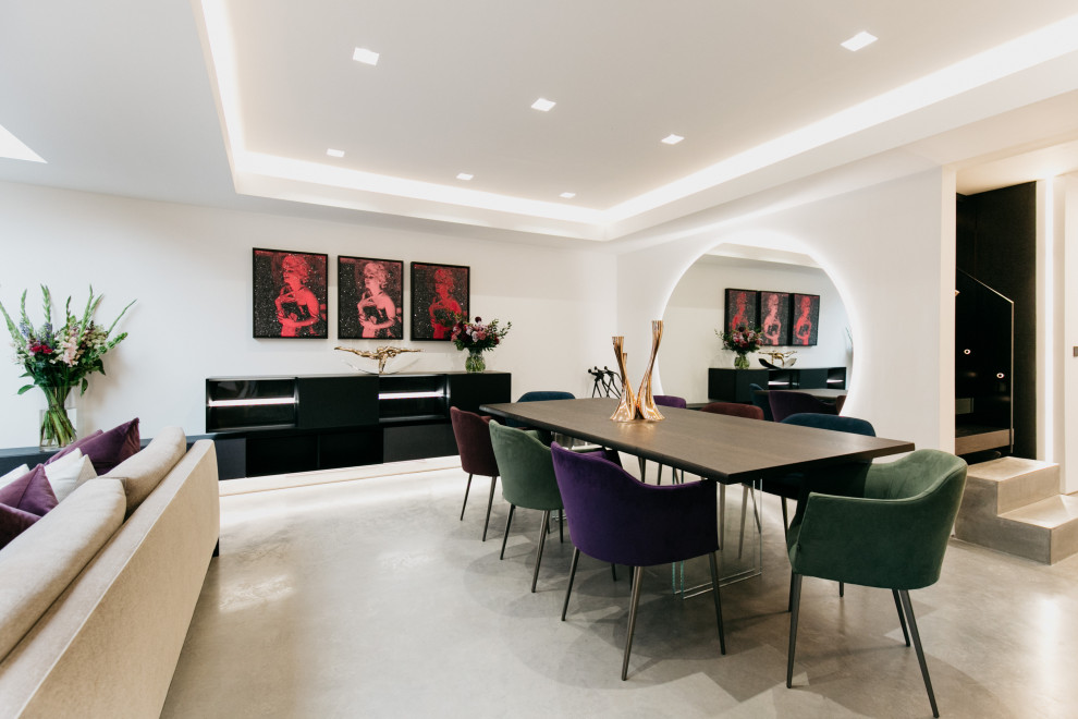 This is an example of a mid-sized contemporary dining room in Dorset with white walls, concrete floors and coffered.
