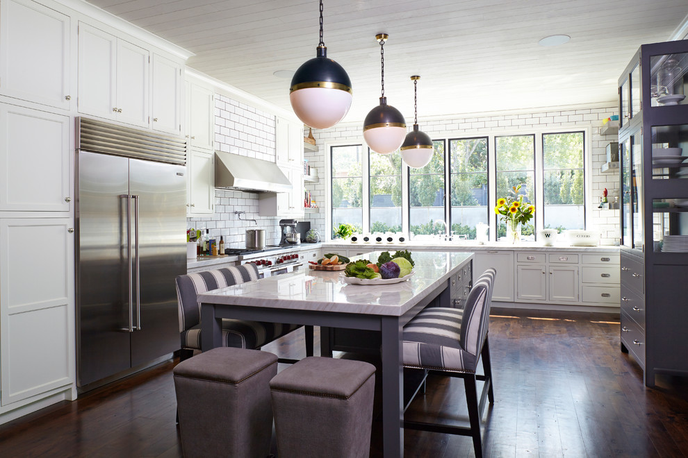 Kitchen - transitional l-shaped dark wood floor and brown floor kitchen idea with shaker cabinets, white cabinets, white backsplash, subway tile backsplash, stainless steel appliances and an island
