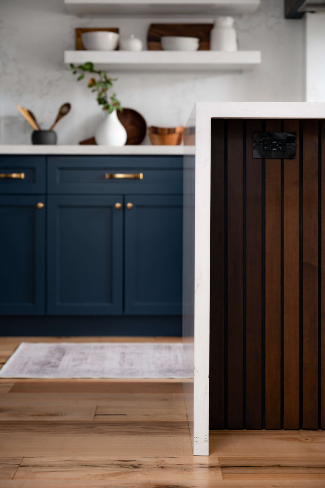 Mid-sized transitional l-shaped medium tone wood floor and beige floor eat-in kitchen photo in Toronto with a farmhouse sink, shaker cabinets, blue cabinets, quartz countertops, white backsplash, quartz backsplash, stainless steel appliances, an island and white countertops