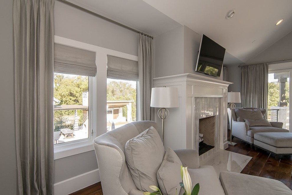 Example of a huge transitional master dark wood floor and brown floor bedroom design in Dallas with gray walls, a standard fireplace and a tile fireplace