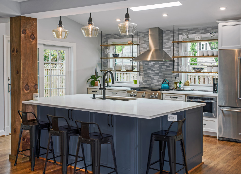 Design ideas for a mid-sized transitional single-wall eat-in kitchen in DC Metro with flat-panel cabinets, blue cabinets, quartz benchtops, blue splashback, glass sheet splashback, stainless steel appliances, with island and grey benchtop.