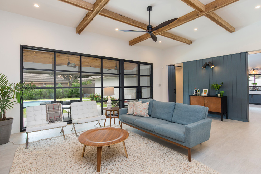 This is an example of a mid-sized contemporary open concept living room in Other with a home bar, white walls, porcelain floors, no fireplace, a wall-mounted tv, white floor, exposed beam and panelled walls.