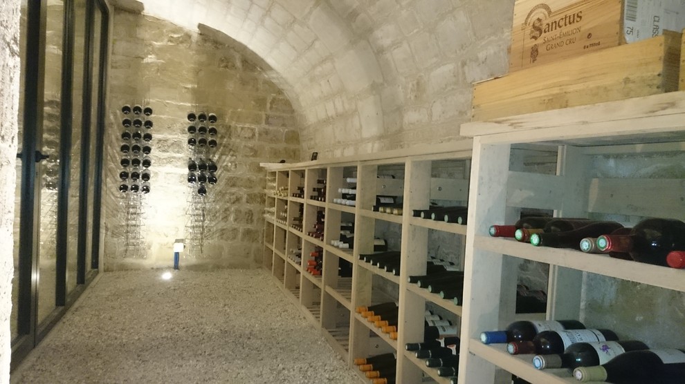 Inspiration pour une grande cave à vin traditionnelle avec des casiers et un sol gris.