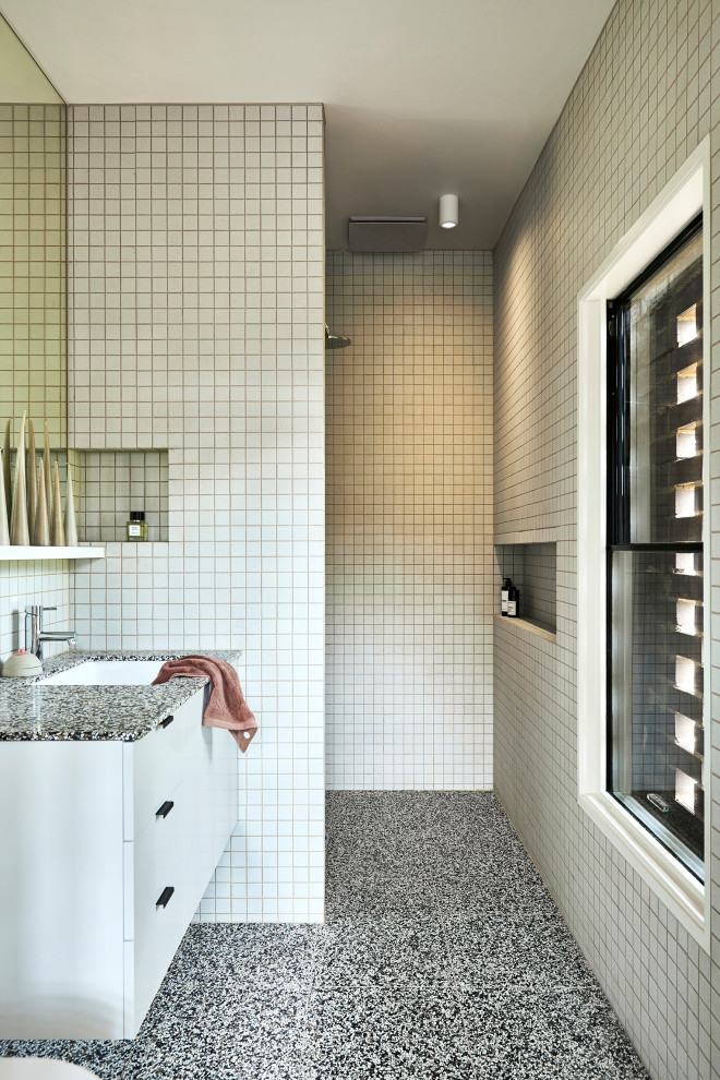 На фото: маленькая главная ванная комната в стиле ретро с белыми фасадами, желтой плиткой, керамической плиткой, полом из терраццо, врезной раковиной, столешницей терраццо, черным полом и черной столешницей для на участке и в саду