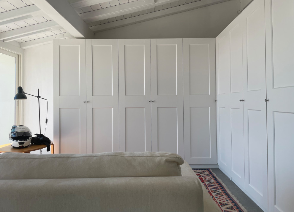 Medium sized contemporary gender neutral dressing room in Other with recessed-panel cabinets, white cabinets, porcelain flooring, grey floors and exposed beams.