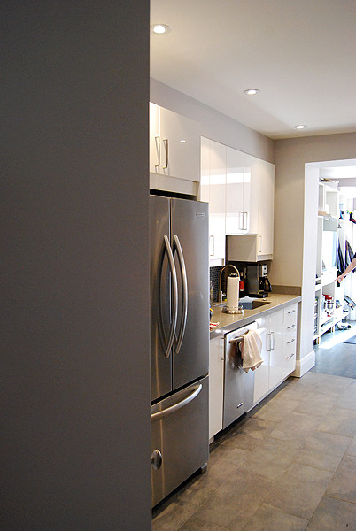 Small contemporary galley eat-in kitchen in Toronto with flat-panel cabinets, white cabinets, concrete benchtops, metallic splashback, porcelain splashback and with island.