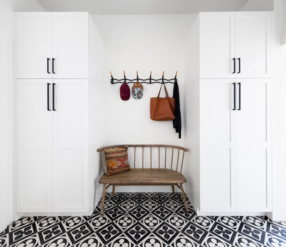 This is an example of a country mudroom in San Francisco with white walls and multi-coloured floor.