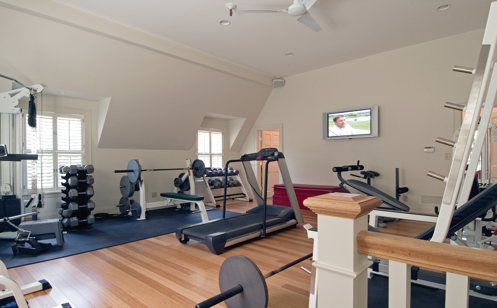 Photo of a large traditional home weight room in Boston with white walls and bamboo floors.