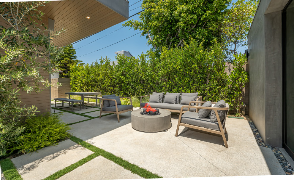 This is an example of a mid-sized contemporary backyard patio in Los Angeles with a fire feature, stamped concrete and no cover.