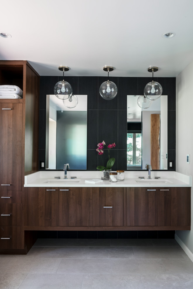 Large modern master bathroom in DC Metro with flat-panel cabinets, dark wood cabinets, a freestanding tub, an open shower, a one-piece toilet, black tile, grey walls, porcelain floors, an undermount sink, solid surface benchtops, grey floor, an open shower and porcelain tile.