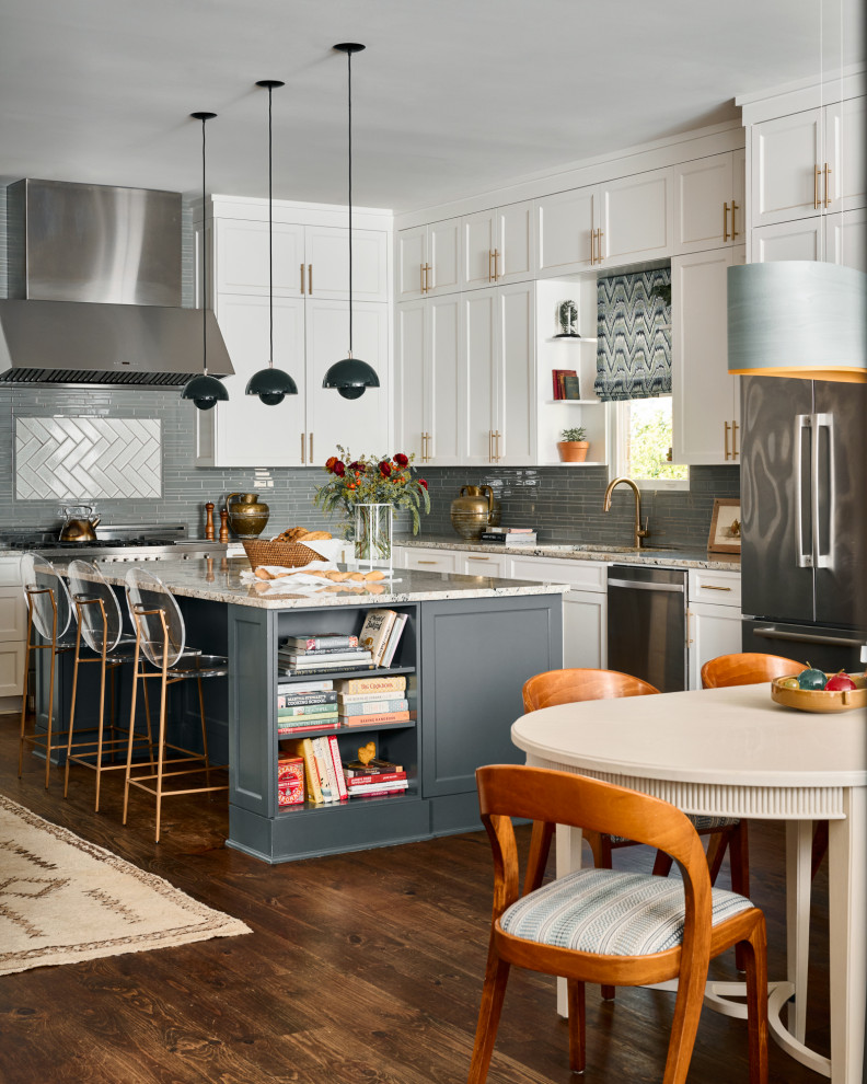 Immagine di un cucina con isola centrale chic con ante bianche, paraspruzzi grigio, elettrodomestici in acciaio inossidabile e pavimento in legno massello medio
