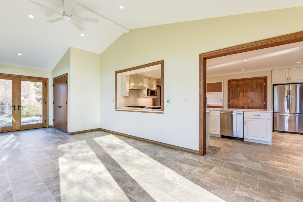 Réalisation d'une grande salle à manger ouverte sur la cuisine minimaliste en bois avec un mur beige, un sol en carrelage de porcelaine et un sol beige.