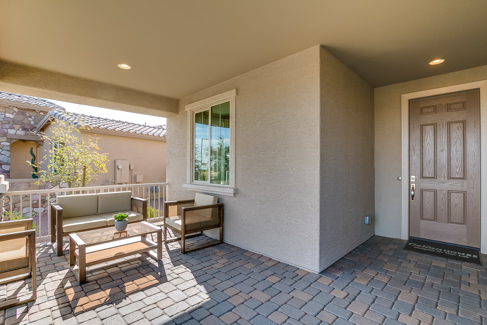 Photo of a mid-sized contemporary front yard patio in Phoenix with brick pavers and a roof extension.