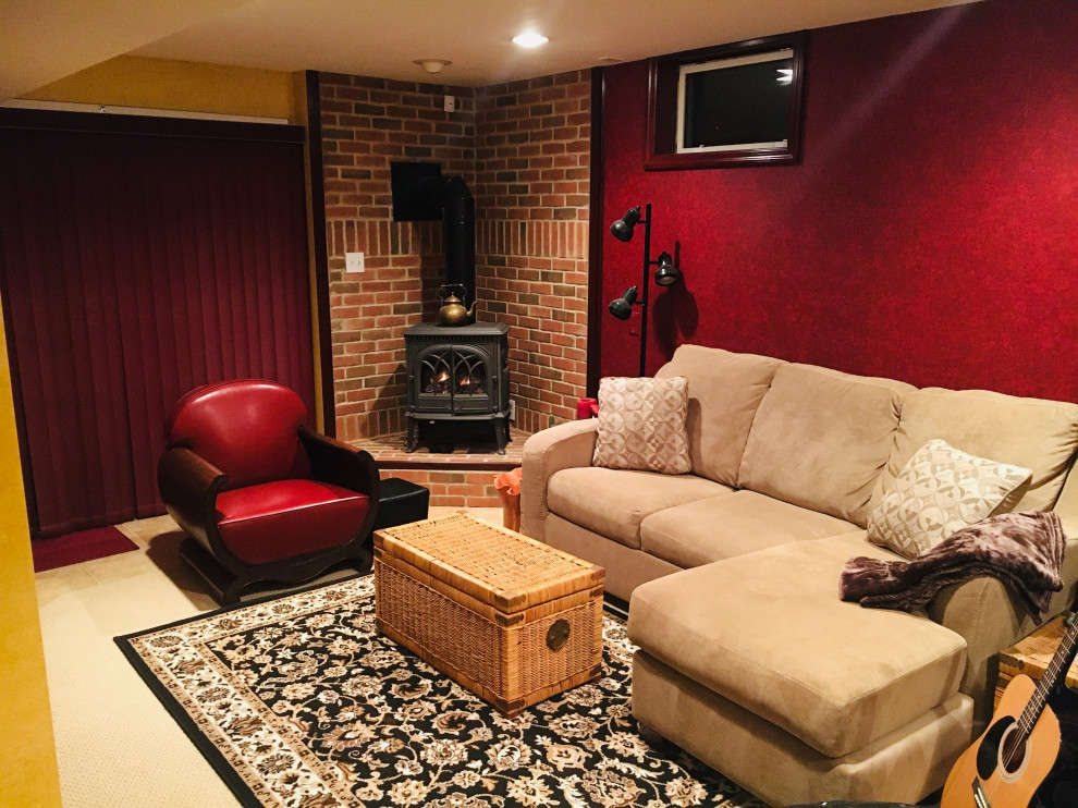 Idées déco pour un sous-sol classique donnant sur l'extérieur et de taille moyenne avec salle de cinéma, un mur rouge, moquette, une cheminée d'angle, un manteau de cheminée en brique et un sol beige.