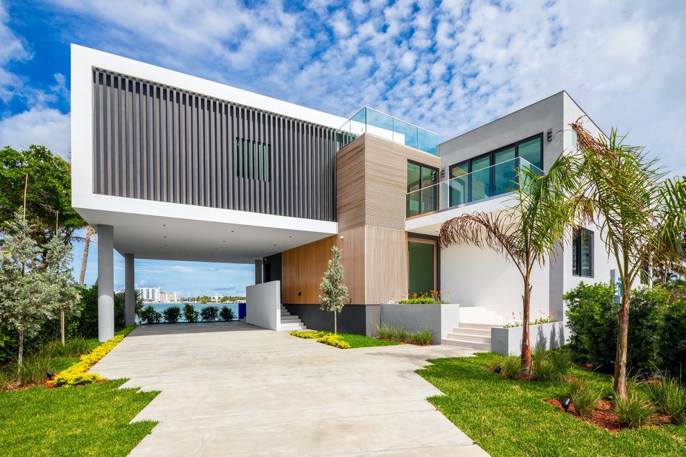 Photo of a contemporary two-storey multi-coloured house exterior in Miami with mixed siding and a flat roof.