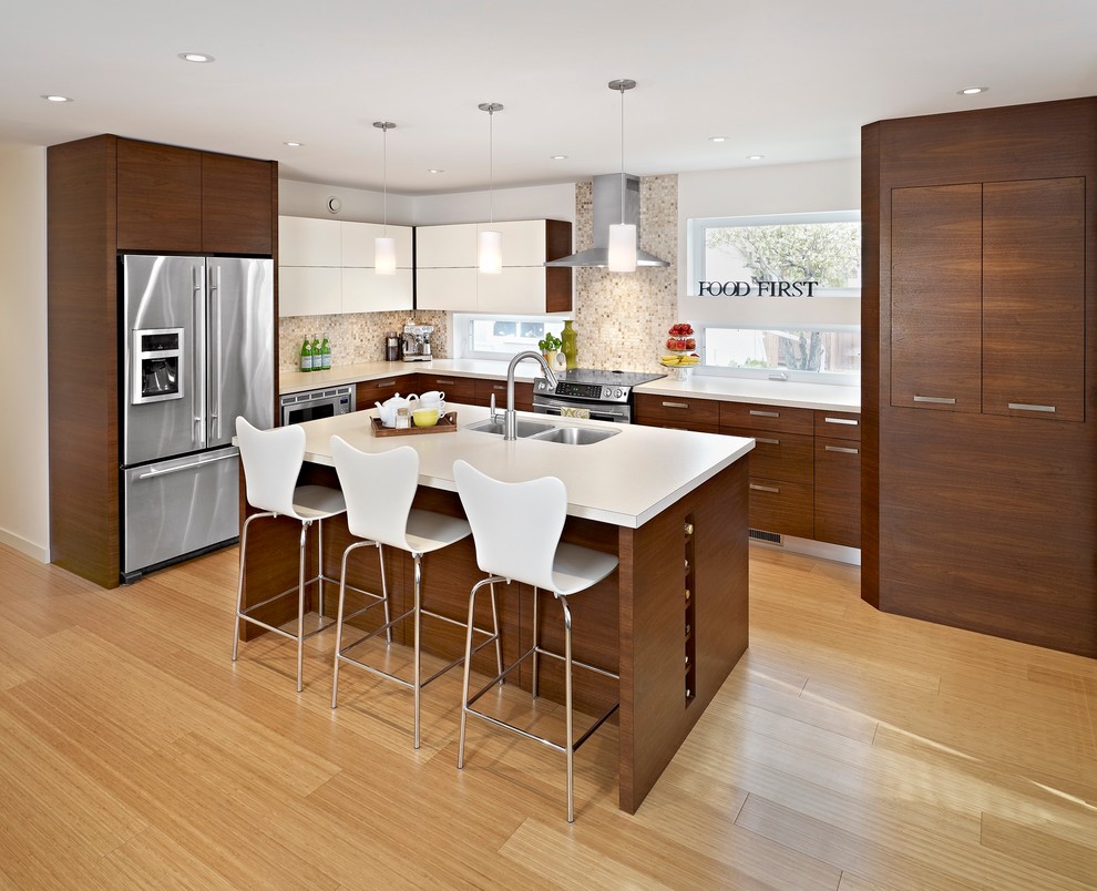 This is an example of a mid-sized contemporary l-shaped eat-in kitchen in Edmonton with an undermount sink, flat-panel cabinets, medium wood cabinets, laminate benchtops, brown splashback, mosaic tile splashback, stainless steel appliances, medium hardwood floors and with island.
