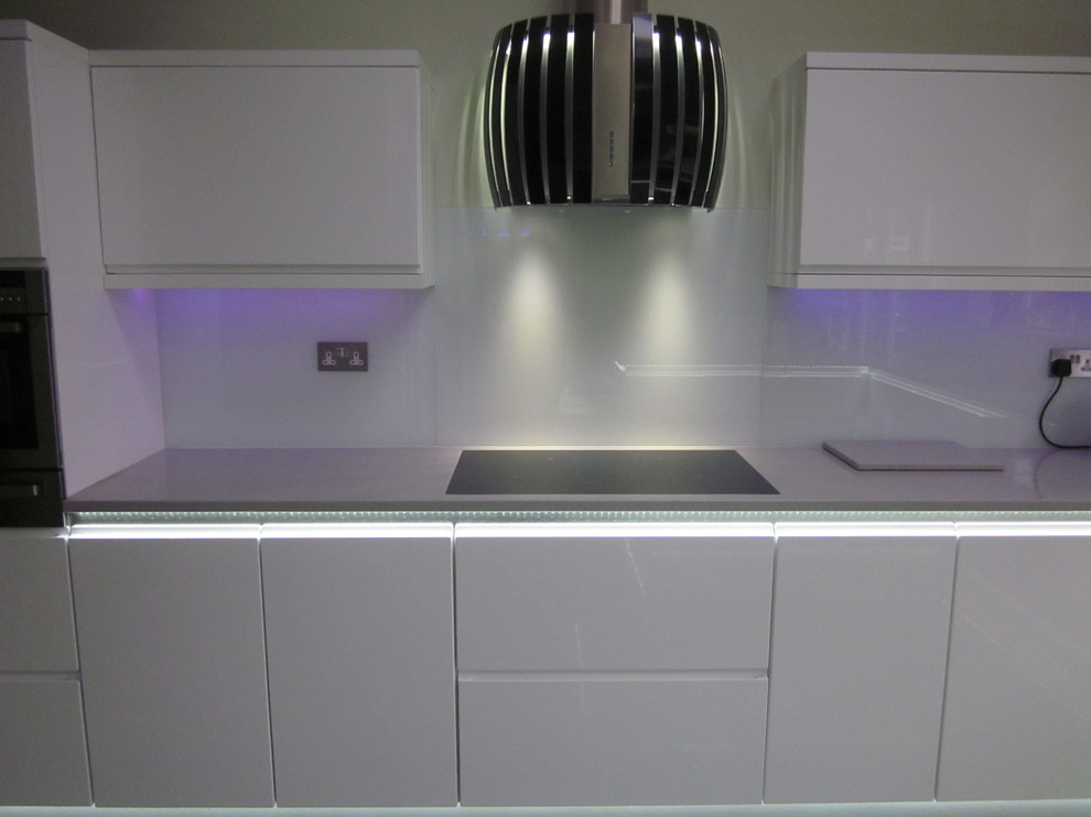 This is an example of a modern eat-in kitchen in Manchester with quartz benchtops.