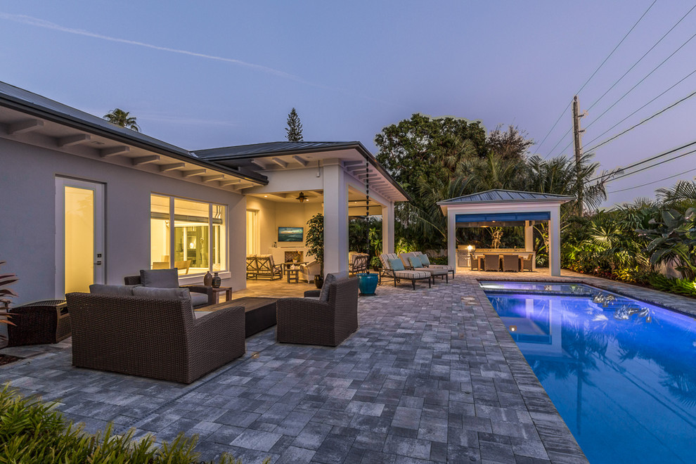 Inspiration for a large transitional one-story and backyard concrete paver and rectangular gray and lap pool remodel in Miami