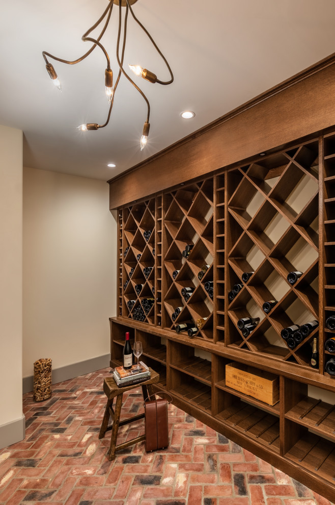 This is an example of a large mediterranean wine cellar in Other with brick floors, diamond bins and pink floor.