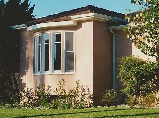 This is an example of a mid-sized traditional one-storey stucco beige exterior in San Diego with a hip roof.
