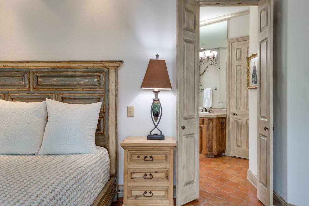 Transitional master bedroom in Dallas with terra-cotta floors.