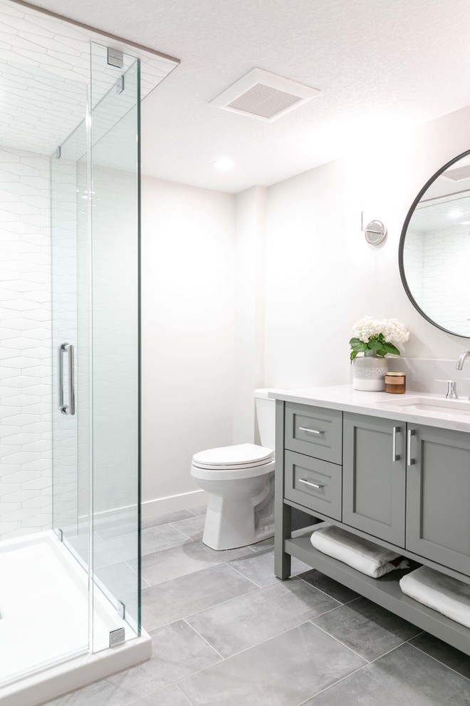 Inspiration for a mid-sized transitional 3/4 white tile and ceramic tile porcelain tile and gray floor doorless shower remodel in Calgary with shaker cabinets, gray cabinets, white walls, an undermount sink, quartzite countertops, a hinged shower door and white countertops