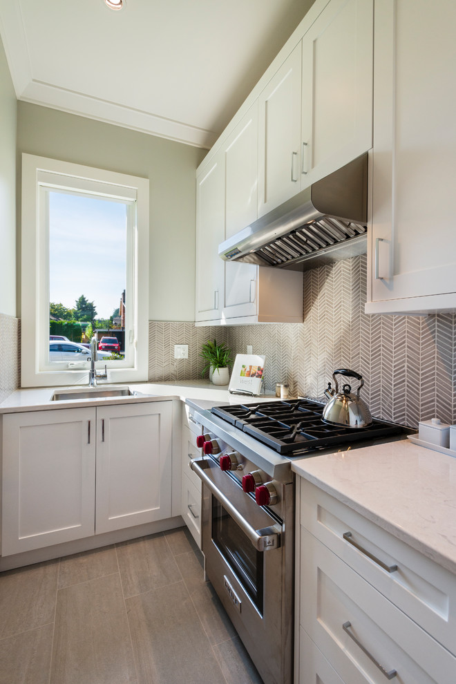 Example of a small transitional l-shaped porcelain tile and beige floor kitchen pantry design in Vancouver with an undermount sink, shaker cabinets, white cabinets, quartz countertops, beige backsplash, mosaic tile backsplash, stainless steel appliances, no island and beige countertops