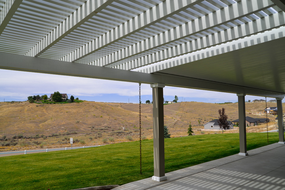 Large transitional backyard patio photo in Boise with a roof extension
