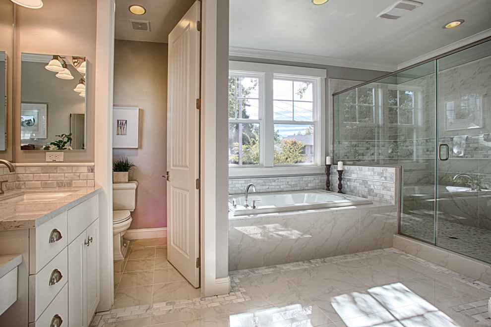 Inspiration for a large arts and crafts master bathroom in San Francisco with white cabinets, white tile, an undermount sink, shaker cabinets, granite benchtops, a drop-in tub, a double shower, a one-piece toilet, mosaic tile, white walls, marble floors and an enclosed toilet.