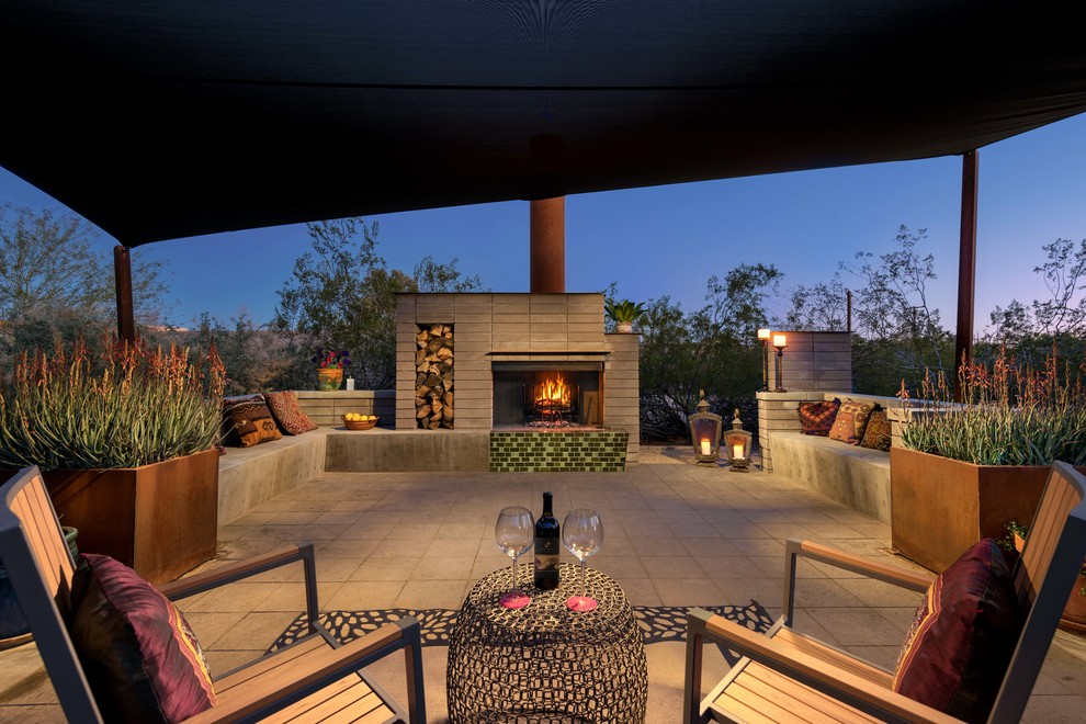 Design ideas for a large midcentury backyard patio in Phoenix with a fire feature, concrete pavers and an awning.