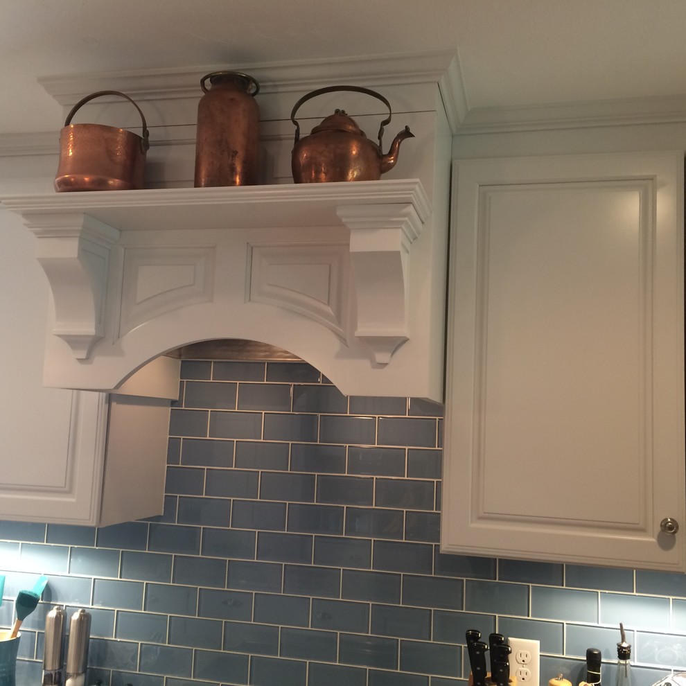 Eat-in kitchen - transitional u-shaped medium tone wood floor eat-in kitchen idea in Boston with an undermount sink, raised-panel cabinets, white cabinets, granite countertops, blue backsplash, glass tile backsplash, stainless steel appliances and an island