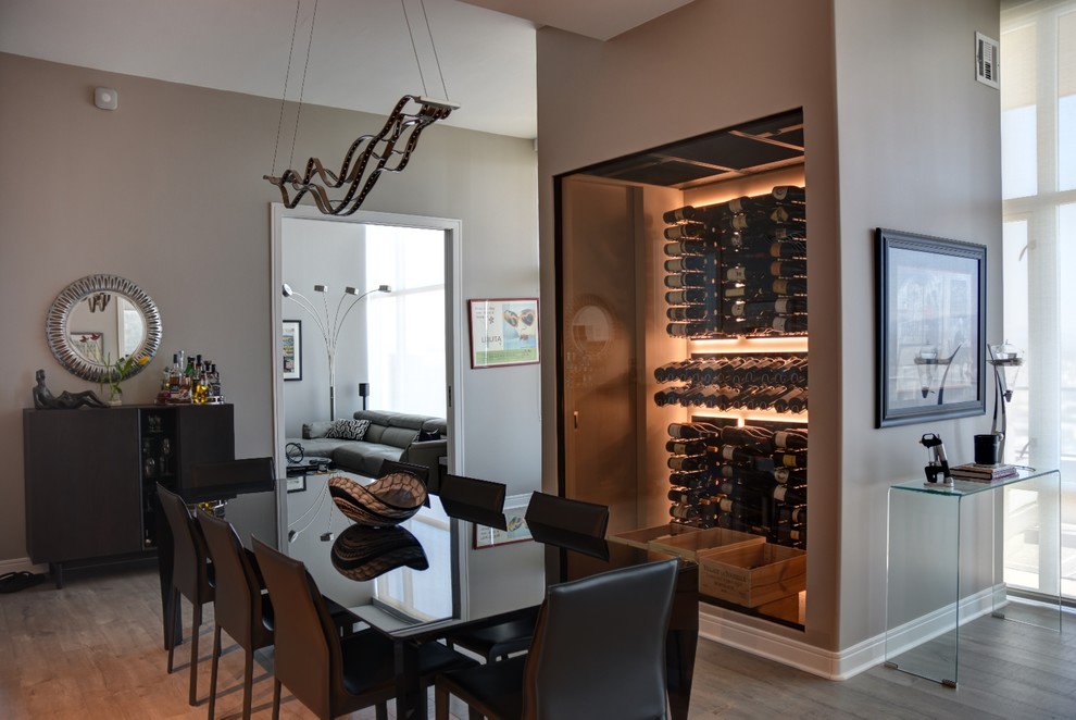 Photo of a small contemporary wine cellar in San Diego with light hardwood floors and display racks.