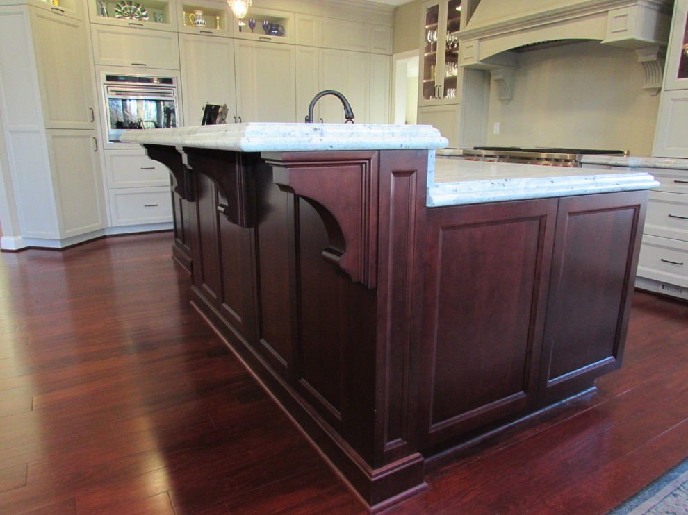 Eat-in kitchen - large transitional l-shaped medium tone wood floor eat-in kitchen idea in DC Metro with an undermount sink, dark wood cabinets, granite countertops, stainless steel appliances and an island