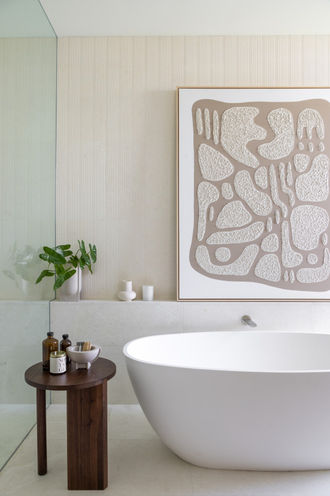 Ejemplo de cuarto de baño moderno con bañera exenta, ducha a ras de suelo y paredes beige