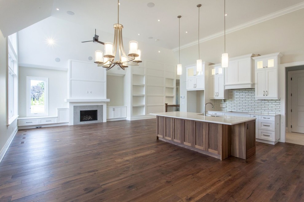 Eat-in kitchen - large transitional l-shaped dark wood floor and brown floor eat-in kitchen idea with a double-bowl sink, shaker cabinets, medium tone wood cabinets, quartz countertops, gray backsplash, glass tile backsplash, stainless steel appliances, an island and white countertops