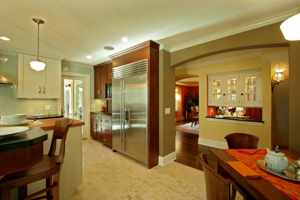 Eat-in kitchen - large transitional u-shaped limestone floor eat-in kitchen idea with a farmhouse sink, shaker cabinets, white cabinets, wood countertops, blue backsplash, glass tile backsplash, stainless steel appliances and beige walls