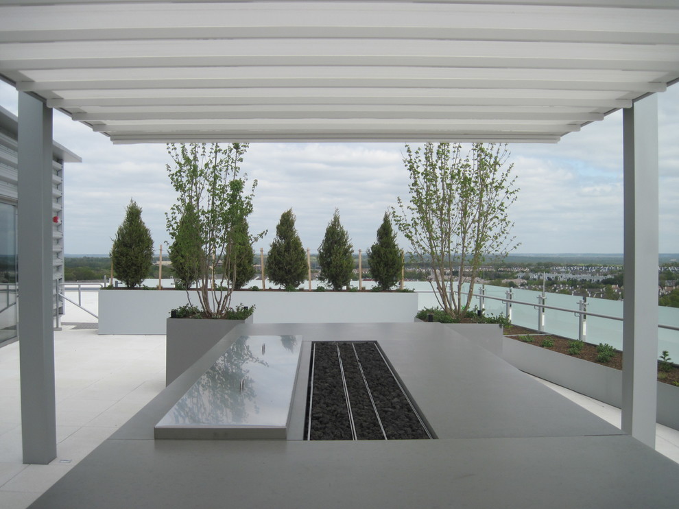 This is an example of a large modern courtyard patio in DC Metro with a pergola and tile.