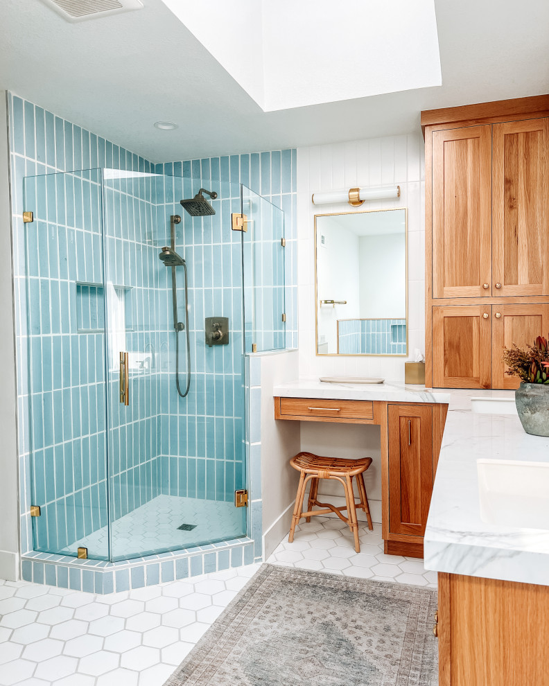 This is an example of a large beach style bathroom in Los Angeles with a corner shower, blue tile, ceramic tile, white walls, ceramic floors, white floor, a hinged shower door, a niche and brick walls.
