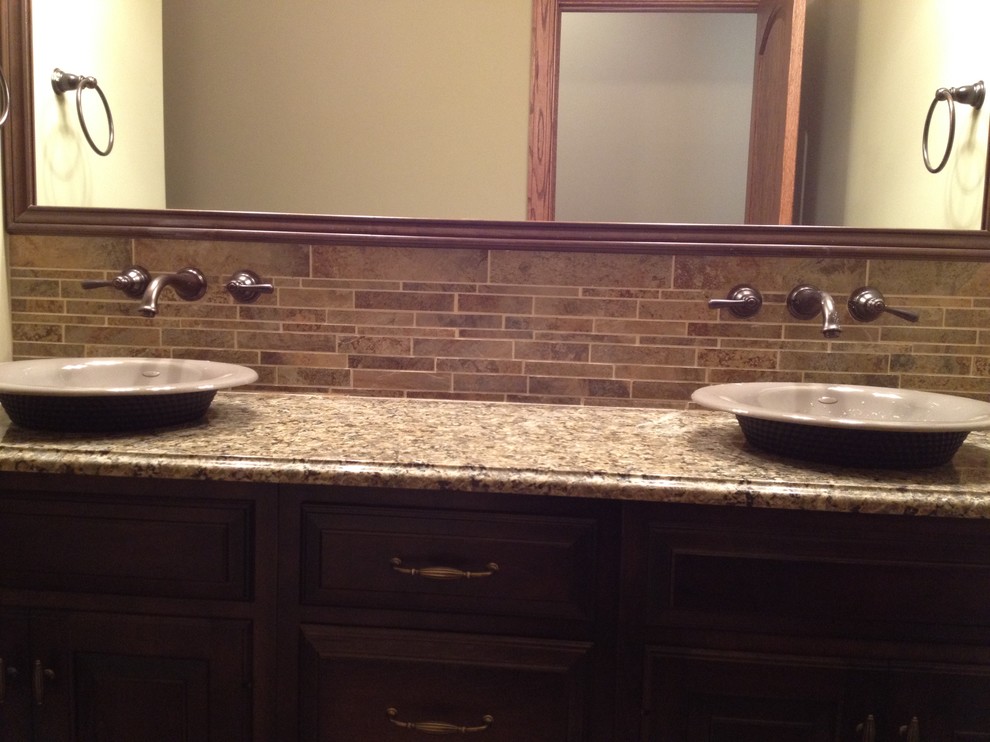 Bathroom - mid-sized brown tile and ceramic tile bathroom idea with a vessel sink, granite countertops and beige walls