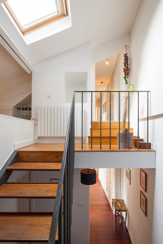 This is an example of a mid-sized contemporary wood u-shaped staircase in Paris with open risers.