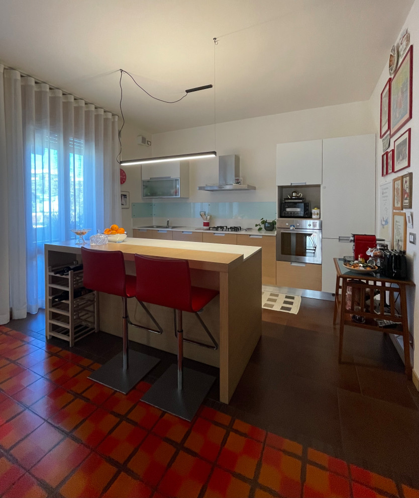 Immagine di una cucina moderna con lavello da incasso, ante lisce, top in quarzo composito, elettrodomestici in acciaio inossidabile e pavimento arancione