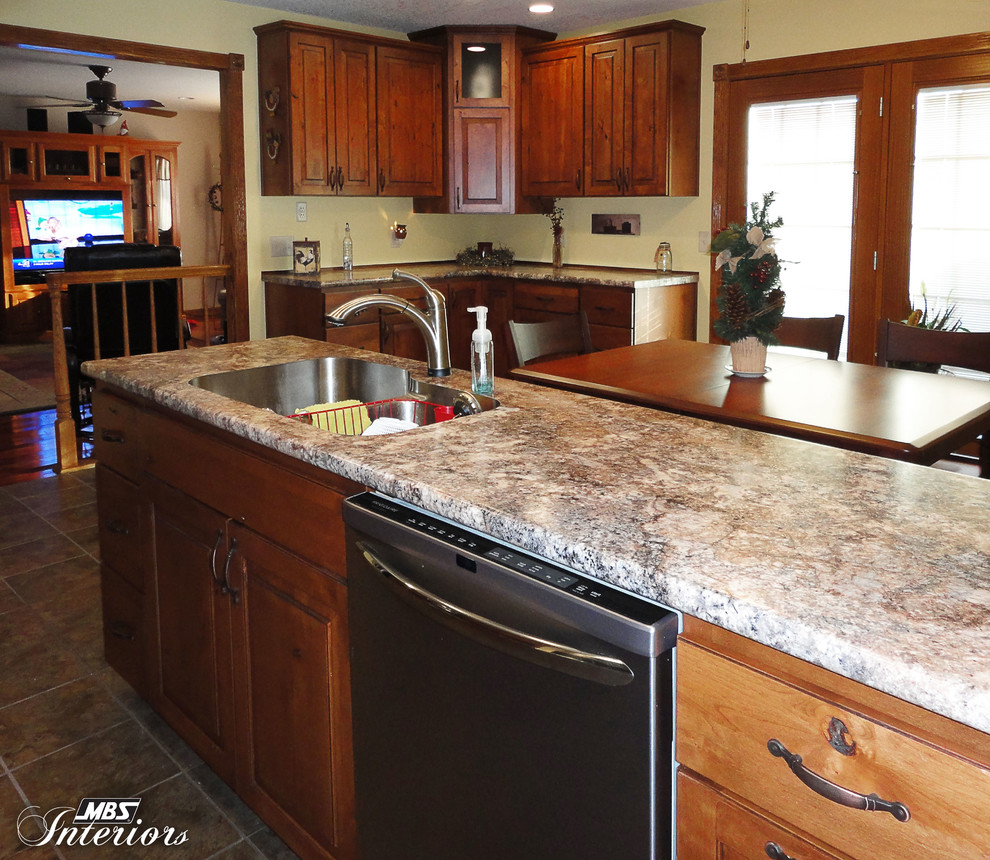 Eat-in kitchen - rustic eat-in kitchen idea with an undermount sink, medium tone wood cabinets, laminate countertops, gray backsplash, metal backsplash and stainless steel appliances