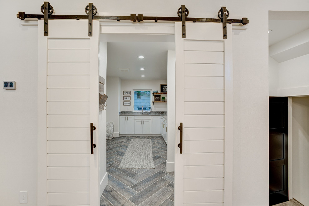 Inspiration for a mid-sized modern l-shaped dedicated laundry room in Denver with an undermount sink, shaker cabinets, white cabinets, quartz benchtops, white walls, porcelain floors, a side-by-side washer and dryer, blue floor and grey benchtop.