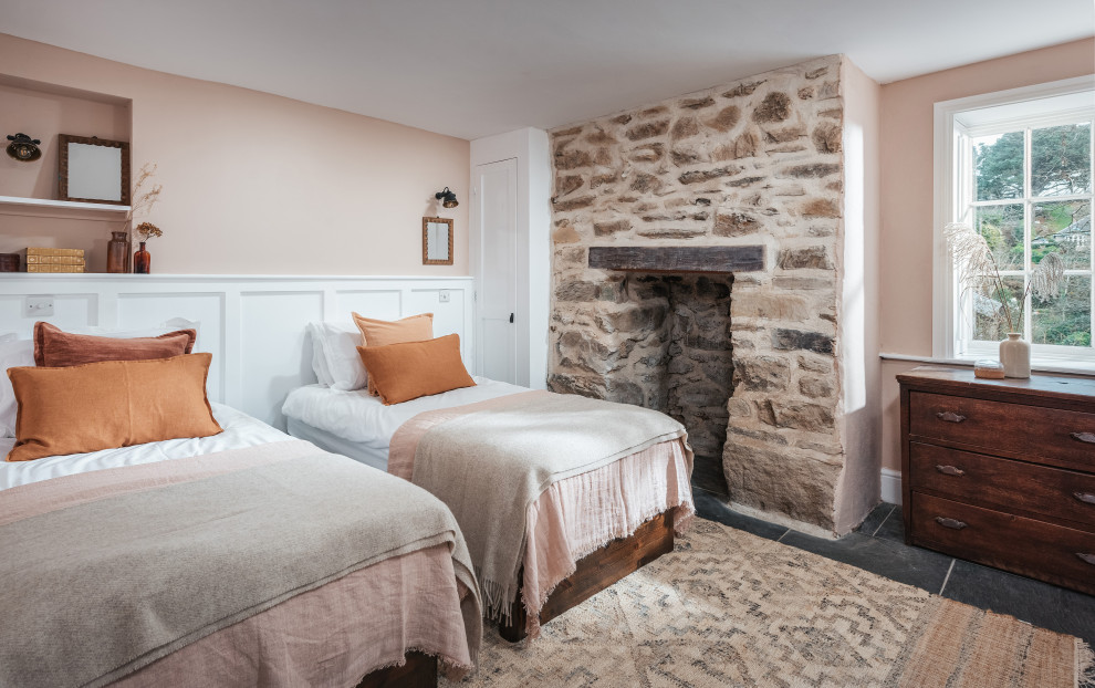 Ejemplo de habitación de invitados costera de tamaño medio con paredes rosas y suelo de pizarra