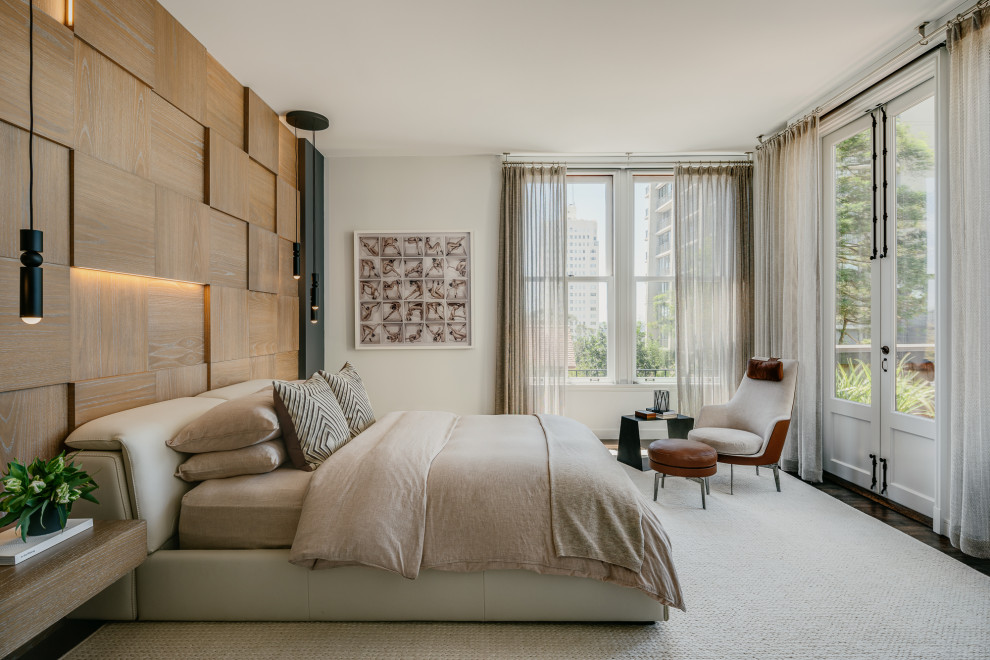 Immagine di una camera da letto design con pareti bianche, parquet scuro, pavimento marrone e pareti in legno
